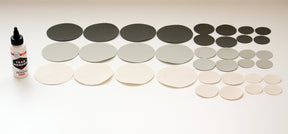 Assorted round fabric patches in gray, black, and beige with Tear Mender adhesive for quick repairs.
