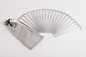 Set of 20 silver metal tent pegs with a gray storage bag for camping and outdoor activities.