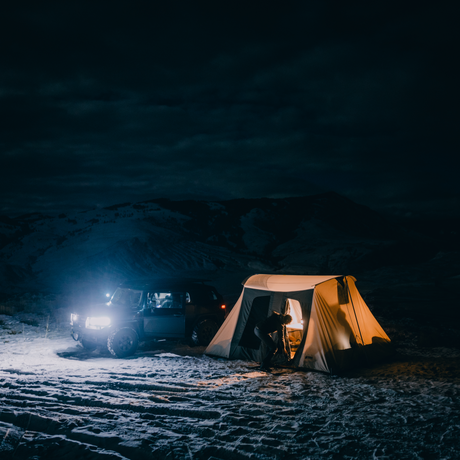 Flex-Bow VX tent at night with lights inside the tent and a truck parked nearby