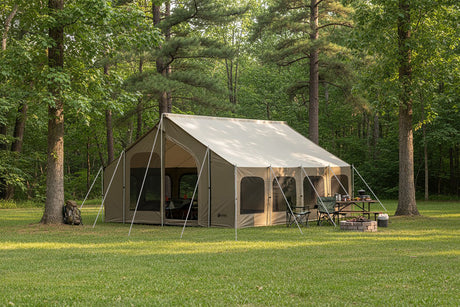 Spacious tan camping tent with mesh windows, set up in a green forest for outdoor adventures.