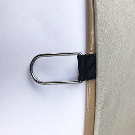 Close-up of beige fabric with a metal D-ring and black strap, ideal for secure fastening.
