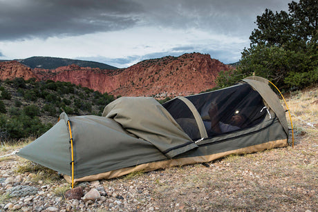 Compact green camping tent with mesh and zip closure, ideal for outdoor adventures.