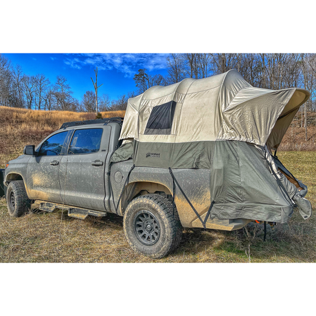 Kromax truck tent in grey, waterproof, mounted on a pickup truck in a rugged outdoor setting.