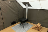 Portable stove on a mat inside a tent with a gray floor
