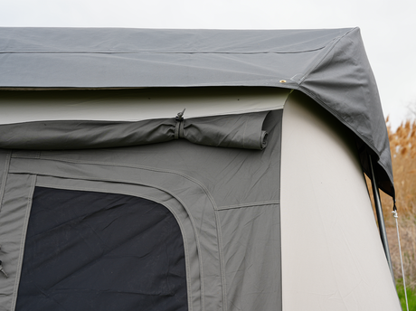 Close-up of a gray camping tent roof highlighting durable fabric and rolled tarp feature.