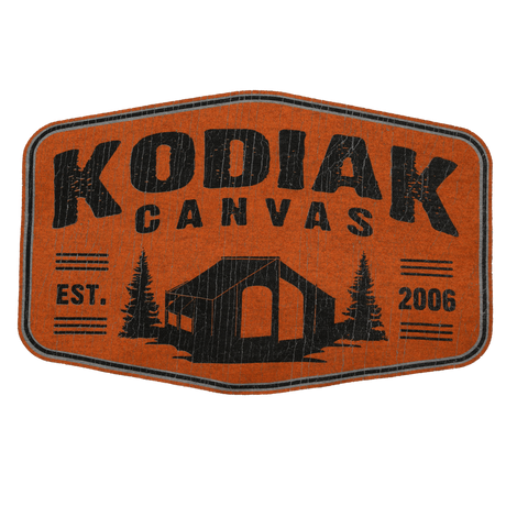 Kodiak Canvas logo patch in orange, featuring a tent and pine trees, established in 2006.